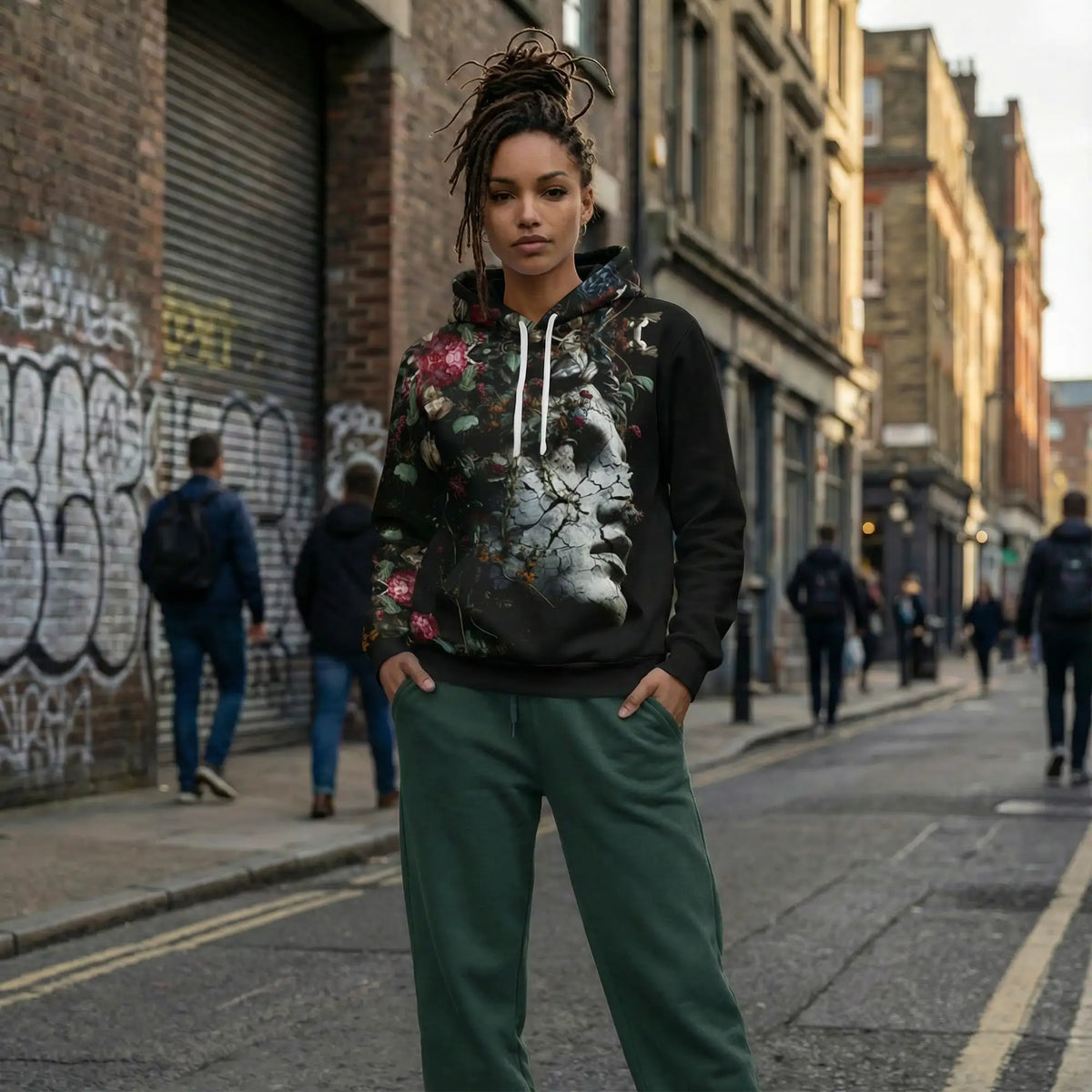 Black hoodie with a detailed floral and cracked face graphic, white drawstrings.