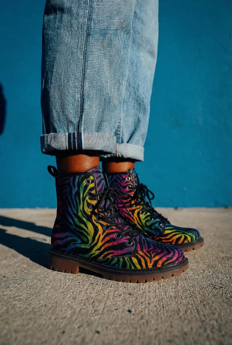 Rainbow zebra-print combat boots with black laces and a brown rubber sole.